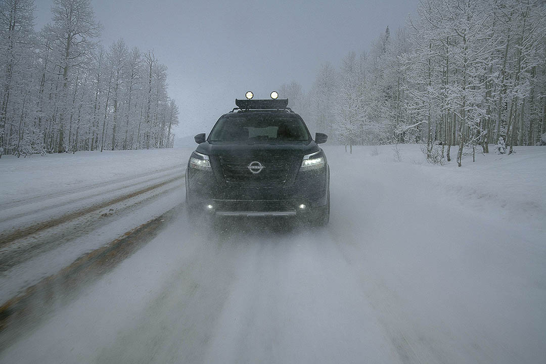 Vue avant du Nissan Pathfinder 2022 roulant sur une route pendant une tempête de neige