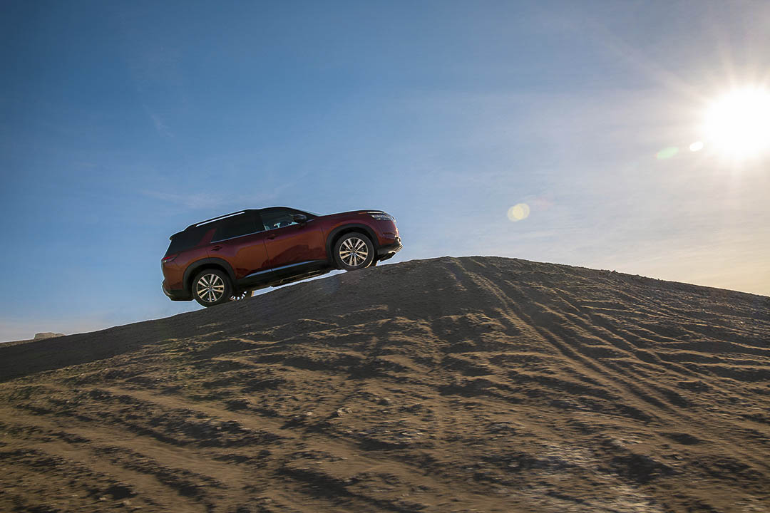 Vue latérale du Nissan Pathfinder 2022 pointant vers le ciel garé sur une bute dans le désert